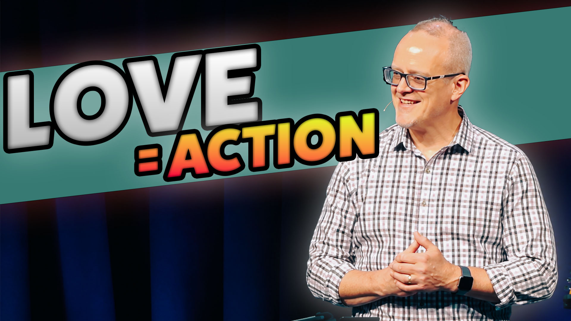 Tim preaching on stage with the words love = actions